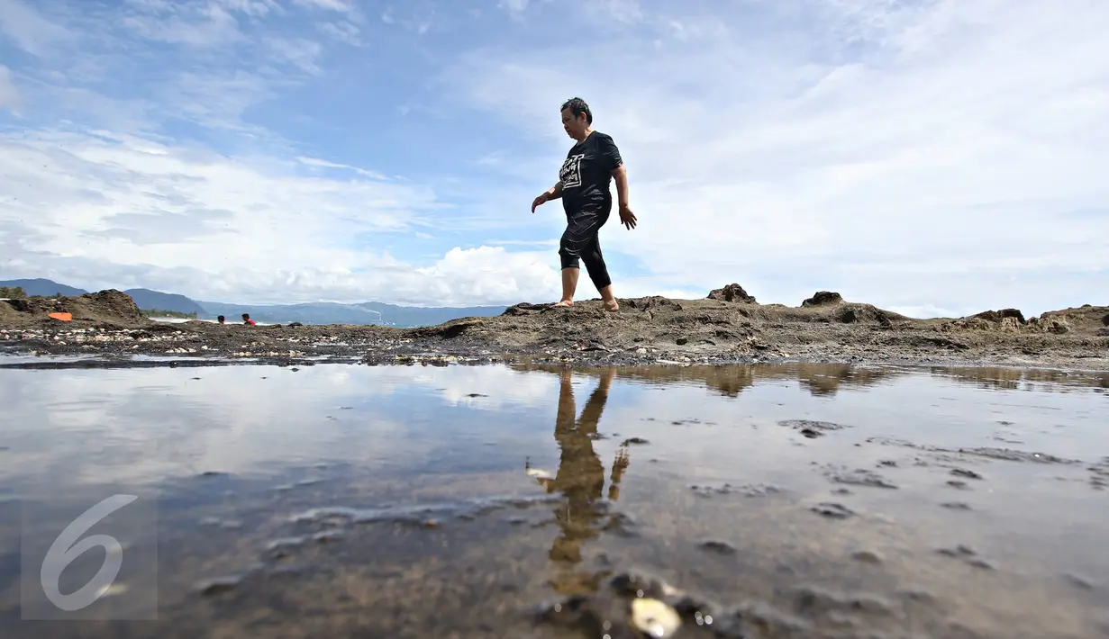 Seorang warga bermain air di sekitar Pantai Karang Hawu, Sukabumi, Jawa Barat, (8/2). ). Mengisi libur Imlek, Sejumlah wisatawan mengunjungi Pantai Karang Hawu. (Liputan6.com/Immanuel Antonius)