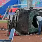 Seorang petugas polisi berpakaian preman memeriksa mobil polisi yang rusak dalam tragedi kerusuhan pada pertandingan sepak bola antara Arema Vs Persebaya di Stadion Kanjuruhan Malang, Jawa Timur, Minggu (2/10/2022). Sejauh ini ada sebanyak 180 orang yang sedang dirawat di beberapa rumah sakit yang tersebar di Malang Raya. (AP Photo/Trisnadi)