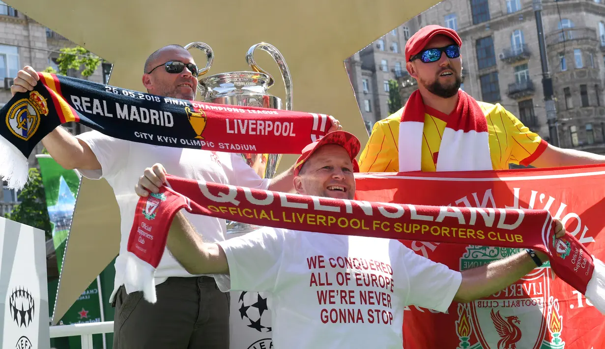 Fans Liverpool berpose dengan piala Liga Champions yang dipamerkan di Kiev, Ukraina , Kamis (24/5). Liverpool akan menghadapi Real Madrid di laga final Liga Champions. (Sergei SUPINSKY/AFP)