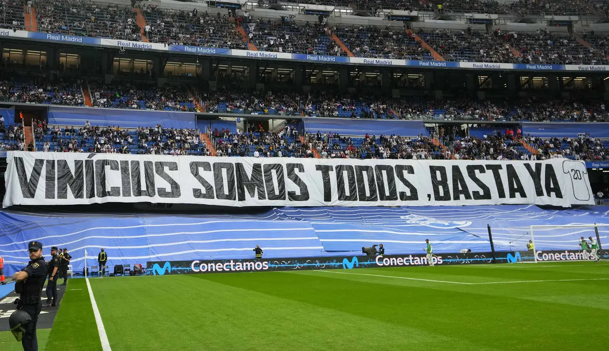 Spanduk bertuliskan "Kita semua Vinicius" terpasang pada laga lanjutan Liga Spanyol 2022/2023 antara Real Madrid melawan Rayo Vallecano pada Kamis (25/05/2023) dini hari WIB. Los Blancos memberikan aksi solidaritas sebelum laga tersebut setelah pemain Brasil itu menjadi korban rasisme pada Minggu (21/05/2023) lalu. (AP Photo/Manu Fernandez)