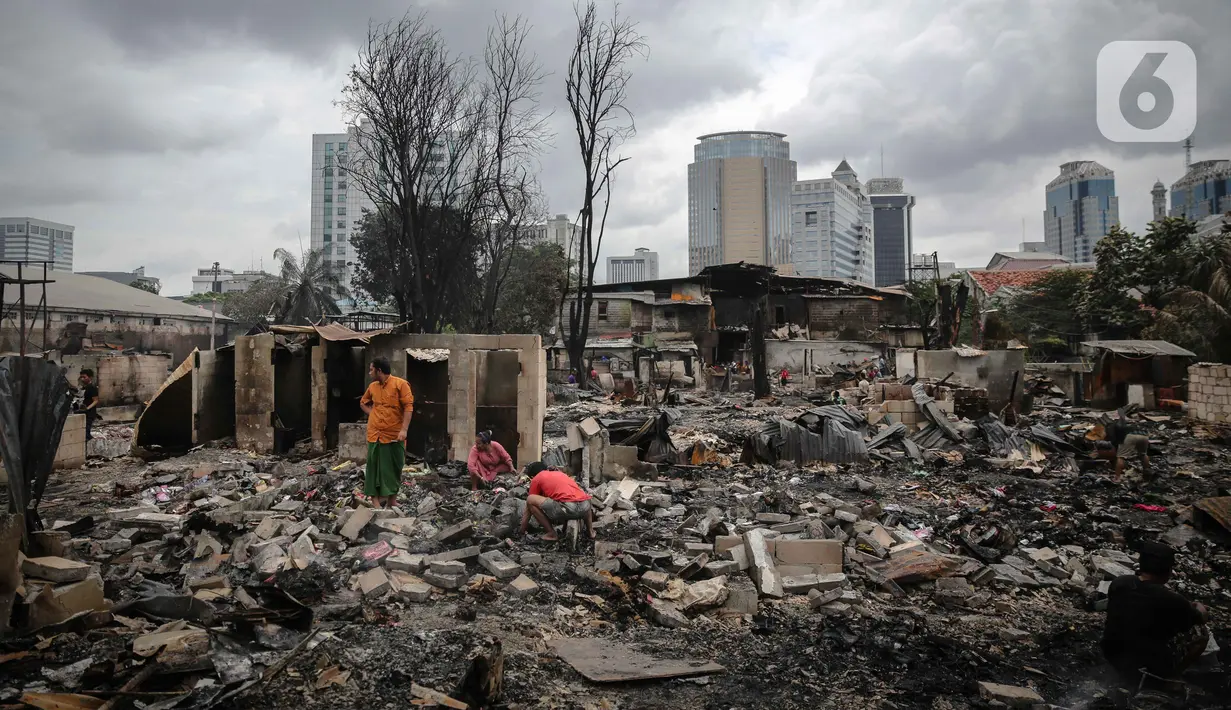Warga mencari barang berharga di sekitar puing-puing bangunan tempat tinggal mereka yang terbakar di Jalan Tanah Abang 5 RT 003,004/RW 003, Petojo Selatan, Gambir, Jakarta Pusat, Senin (27/2/2023). Api selesai dipadamkan pada Senin (27/2/2023) pukul 01.18 WIB. Sementara itu, penyebab kebakaran masih dalam proses pendataan. (Liputan6.com/Faizal Fanani