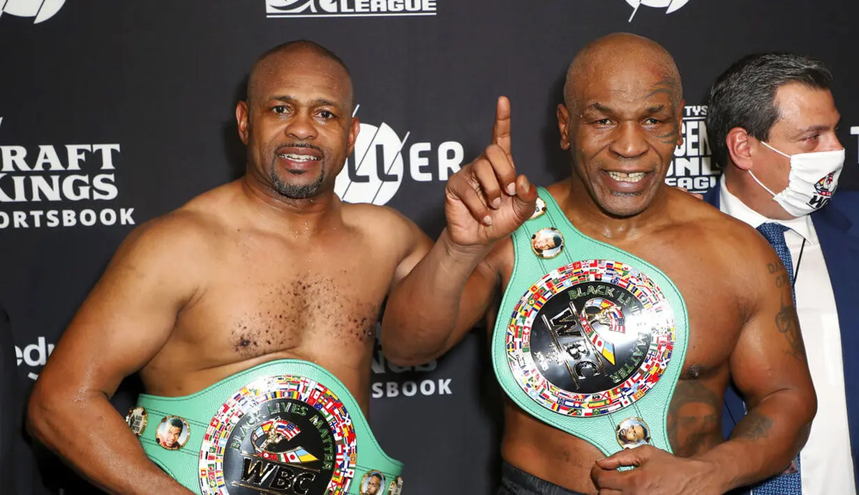 Roy Jones Jr (kiri) dan Mike Tyson berfoto bersama usai bertanding pada pertarungan tinju eksibisi di Los Angeles, Amerika Serikat, Sabtu (28/11/2020). Pertandingan berakhir tanpa pemenang alias imbang. (Joe Scarnici/Triller via AP)