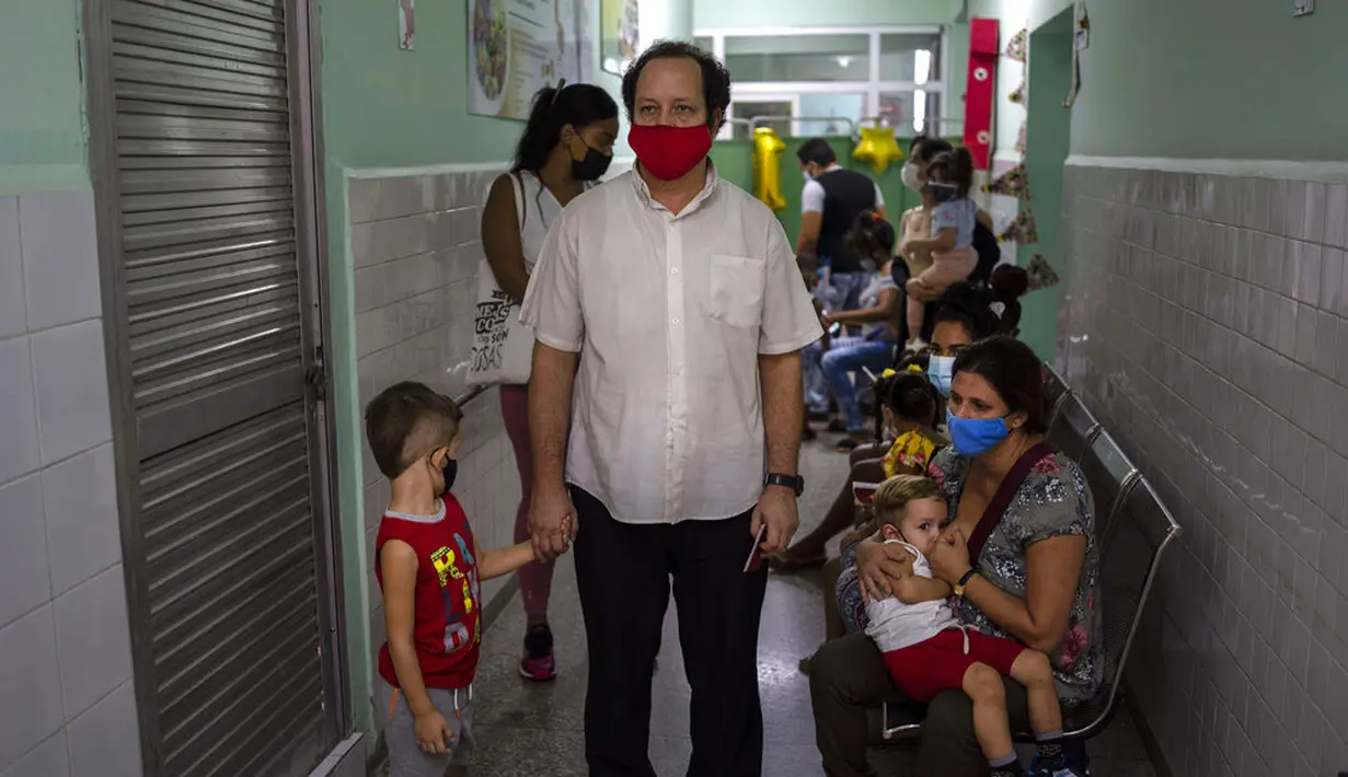Orang tua menunggu bersama anak mereka untuk menerima dosis vaksin COVID-19 Soberana-02 di sebuah klinik di Havana, Kuba, Kamis (17/9/2021). Pemerintah Kuba memulai vaksinasi Covid-19 bagi anak-anak berusia 2 tahun dengan vaksin buatan dalam negeri. (AP Photo/Ramon Espinosa)