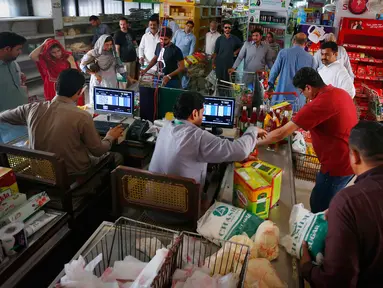Pembeli antre menunggu untuk membayar belanjaan mereka di supermarket yang dikelola pemerintah Pakistan di Islamabad, Rabu (16/5). Warga berbelanja untuk berbagai persiapan Puasa Ramadan yang dimulai pada Kamis (17/5). (AP/Anjum Naveed)