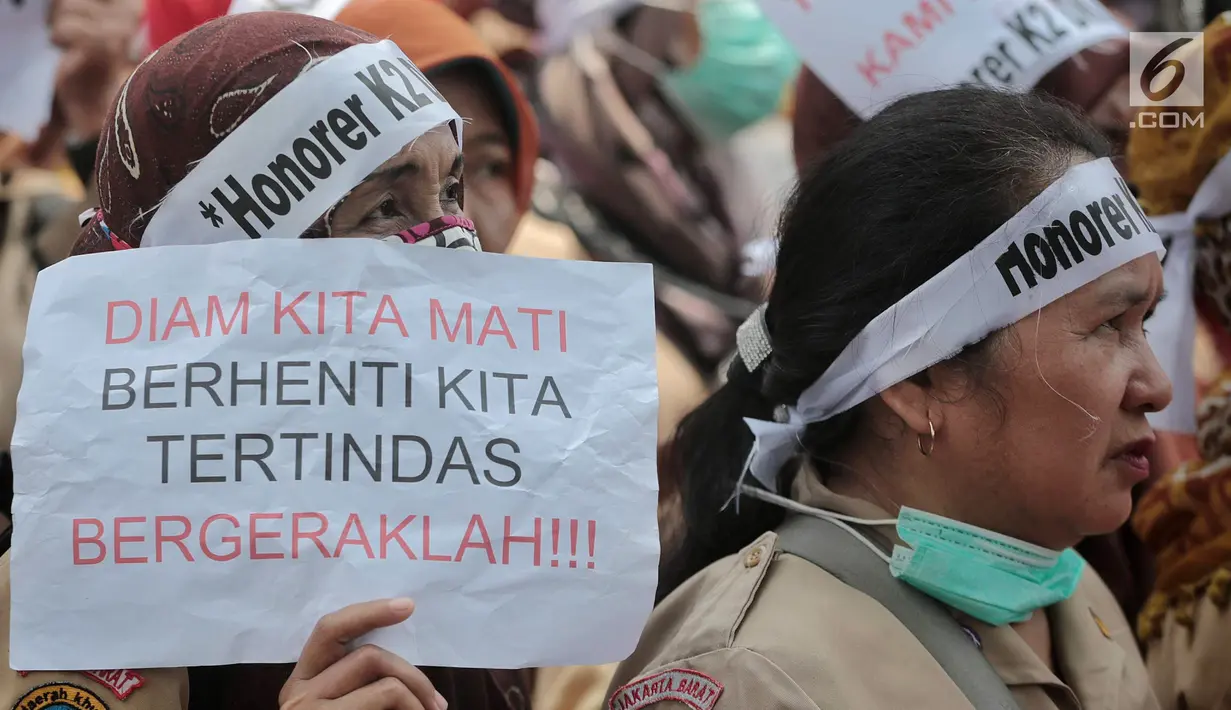 Pegawai honorer DKI Jakarta membawa kertas bertuliskan aspirasi saat menggelar demo di Balai Kota, Jakarta, Rabu (26/9). Peraturan Menteri PAN-RB (Permenpan) Nomor 36 dan 37 tahun 2018. (Liputan6.com/Faizal Fanani)