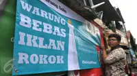 Siswa SMP N 104 Jakarta memasang banner di salah satu warung di kawasan Mampang Prapatan, Jakarta, Kamis (5/11). Aksi ini sebagai bentuk kesadaran tentang ancaman adiksi rokok terhadap anak-anak di sekolah melalui iklan (Liputan6.com/Gempur M Surya)