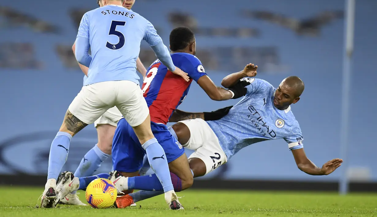 Gelandang Manchester City, Fernandinho berusaha merebut bola pemain Crystal Palace, Jordan Ayew pada pertandingan lanjutan Liga Inggris di Stadion Etihad, Senin (18/1/2021).  City menang telak atas Crystal Palace 4-0. (Peter Powell/Pool via AP)
