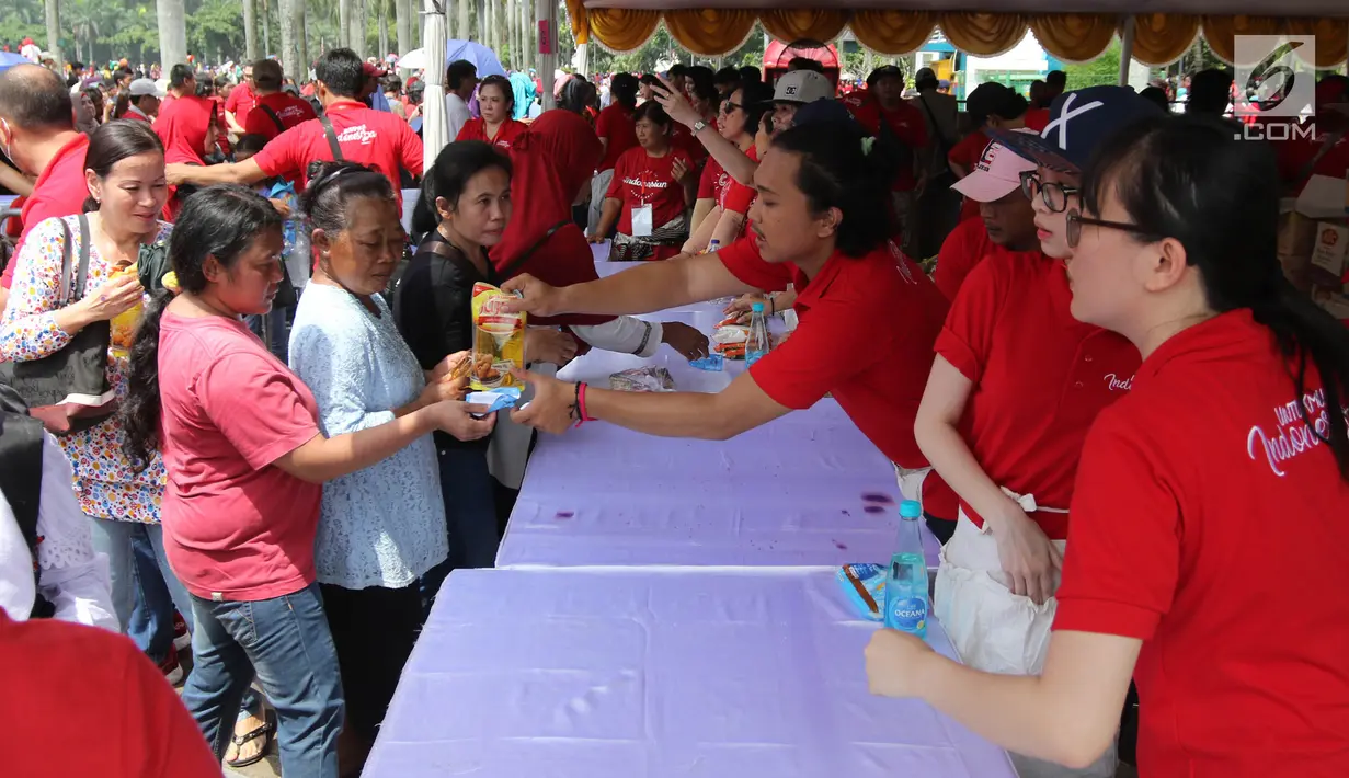 Warga menukarkan kupon untuk mendapatkan sembako gratis dalam acara "Untukmu Indonesia" di lapangan Monas, Jakarta, Sabtu (28/4). (Liputan6.com/Arya Manggala)