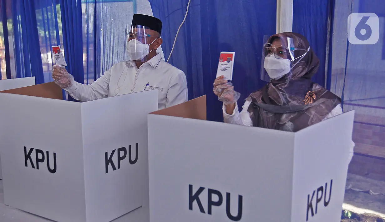 Calon Wali Kota Depok nomor urut 2 Mohammad Idris ditemani istrinya Elly Farida menggunakan hak pilih pada Pilkada 2020 di TPS 14 Jatimulya, Depok, Rabu (9/12/2020). Pilkada Depok 2020 diikuti oleh Pradi Supratna-Afifah Alia serta Mohammad Idris dan Imam Budi Hartono. (Liputan6.com/Herman Zakharia)