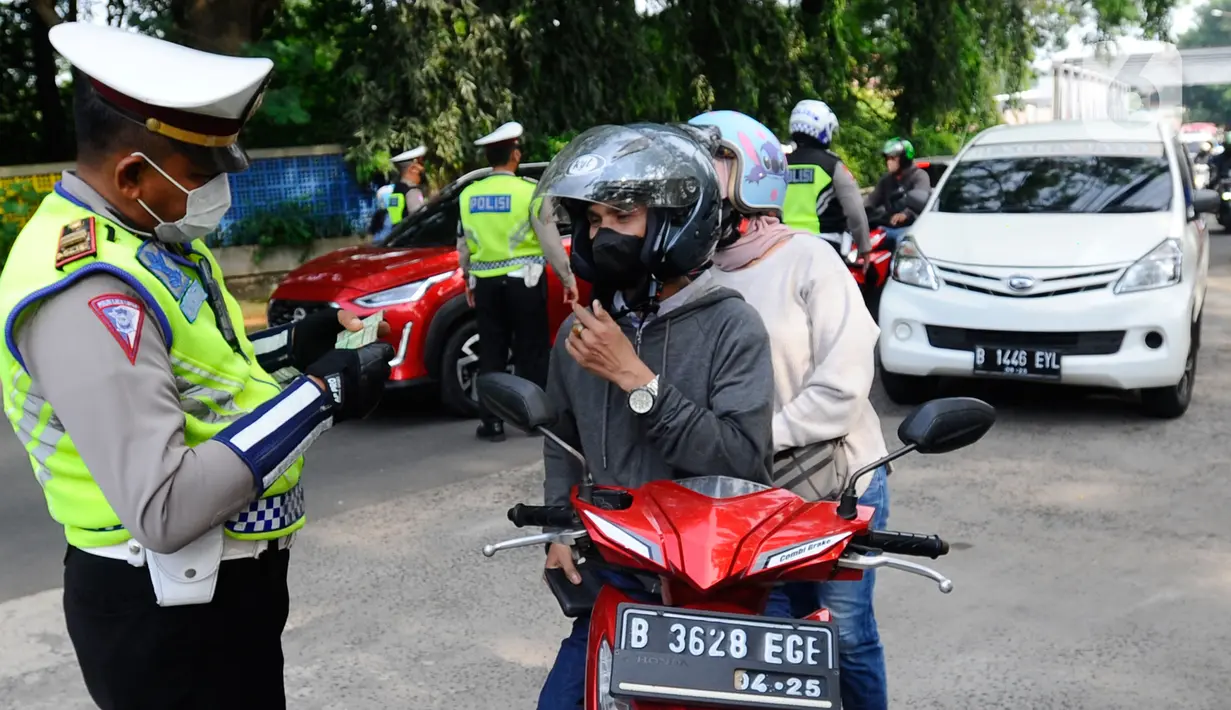 Polantas Polres Depok memeriksa surat tanda nomor kendaraan (STNK) saat Operasi Gabungan Tertib Administrasi Kendaraan Bermotor (KBM) Kendaraan Tidak Mendaftar Ulang (KTMDU) 2022 di Jembatan Panus, Depok, Kamis (9/6/2022). Ratusan kendaraan bermotor yang belum membayar pajak atau kendaraan tidak melakukan daftar ulang (KTMDU) terjaring dalam razia yang dilakukan Sistem Administrasi Manunggal Satu Atap (Samsat) Depok ini. (merdeka.com/Arie Basuki)