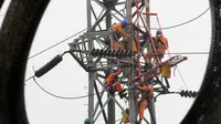 Petugas PLN memperbaiki Menara Sutet di Jalan Asia Afrika, Jakarta, Rabu (12/8/2015). Pekerjaan tersebut mengandung resiko besar karena jaringan listrik masih dipelihara tanpa dipadamkan. (Liputan6.com/Helmi Afandi)