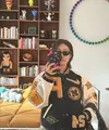 Peggy Gou kenakan varsity jaket dengan nuansa hitam, putih, dan kuning. Jaket Nike tersebut tampak statement dengan tempelan emblem yang menyempurnakan gaya. [Foto: Instagram/ Peggy Gou]