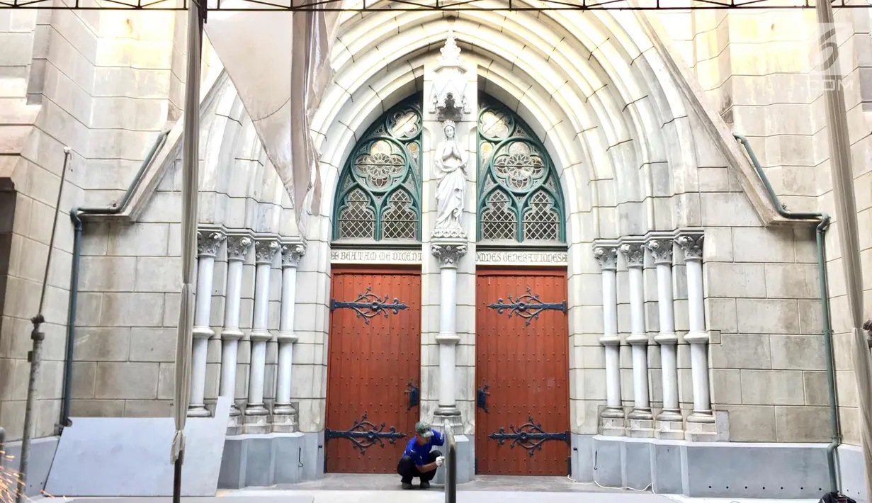 Pekerja membersihkan besi pembatas di gerbang Gereja Katedral, Jakarta, Selasa (19/12). Jelang Hari Natal, persiapan seperti perawatan interior-eksterior serta pemasangan dekorasi mulai dilakukan pihak gereja. (Liputan6.com/Immanuel Antonius)