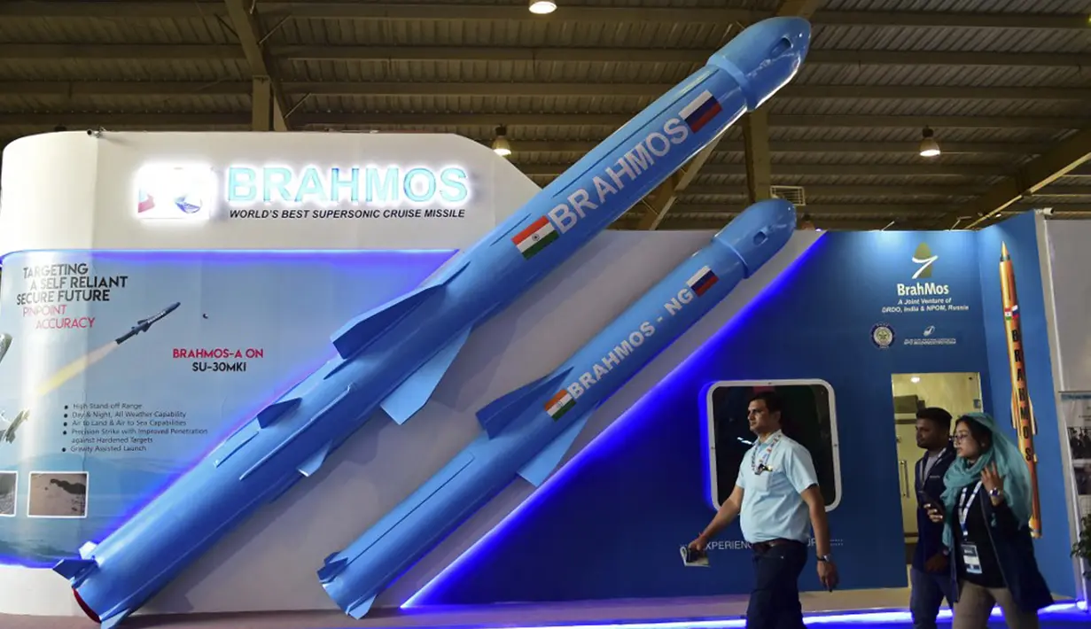 Pengunjung berjalan melewati model rudal jelajah supersonik Brahmos India yang dipamerkan di Defense Expo 2022, Gandhinagar, India, 18 Oktober 2022. Defense Expo 2022 ini akan berlangsung selama lima hari. (Sam PANTHAKY/AFP)