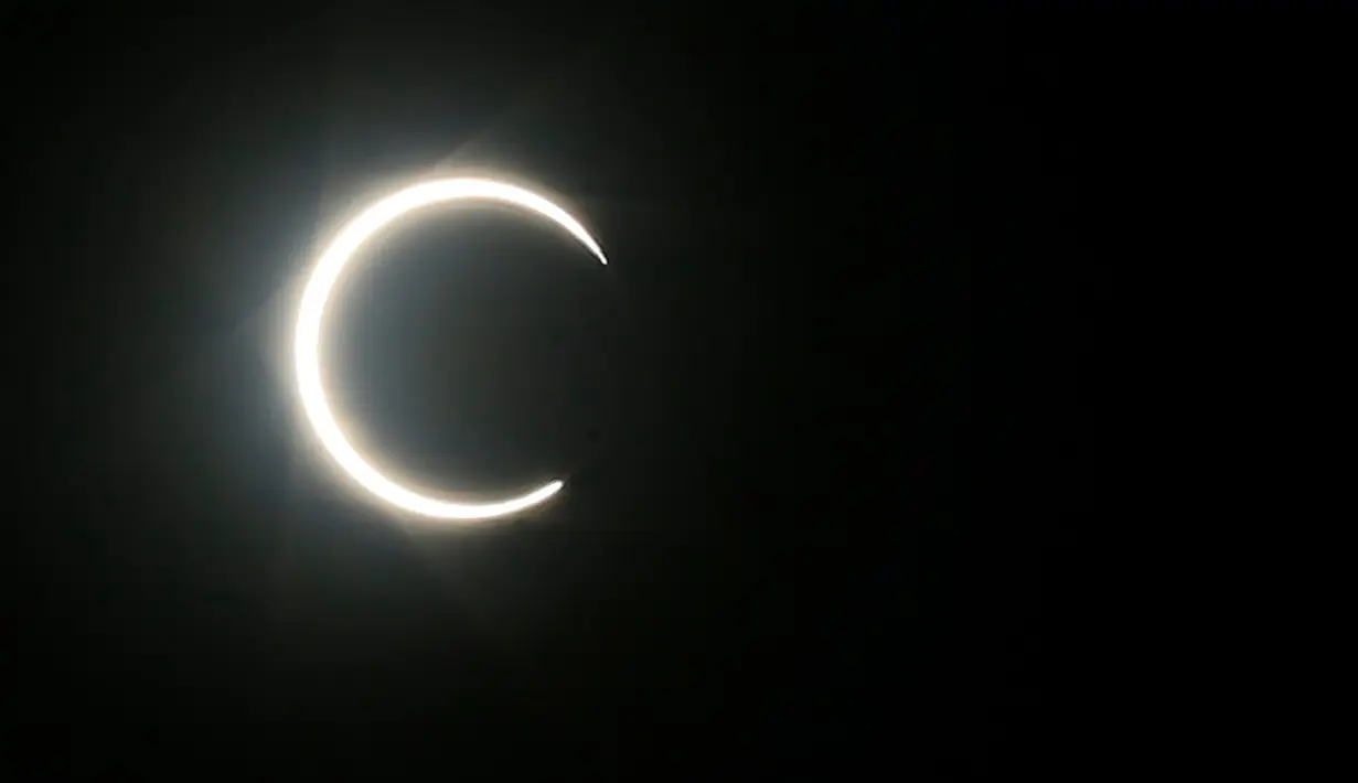 Bulan sebagian menutupi matahari selama gerhana matahari cincin (Annular Solar Eclipse) yang terlihat di ibu kota Yaman, Sanaa, Minggu (21/6/2020). Dunia menikmati Gerhana Matahari Cincin dan Gerhana Matahari Sebagian pada Minggu 21 Juni 2020. (Mohammed HUWAIS / AFP)