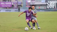 Pemain Persebaya Surabaya, Sho Yamamoto, berusaha melewati pemain Persita Tangerang, Bae Sin-yeong, pada laga Liga 1 di Stadion Indomilk Arena, Tangerang, Rabu (18/1/2023). Persebaya menang dengan skor 5-0. (Bola.com/M Iqbal Ichsan)