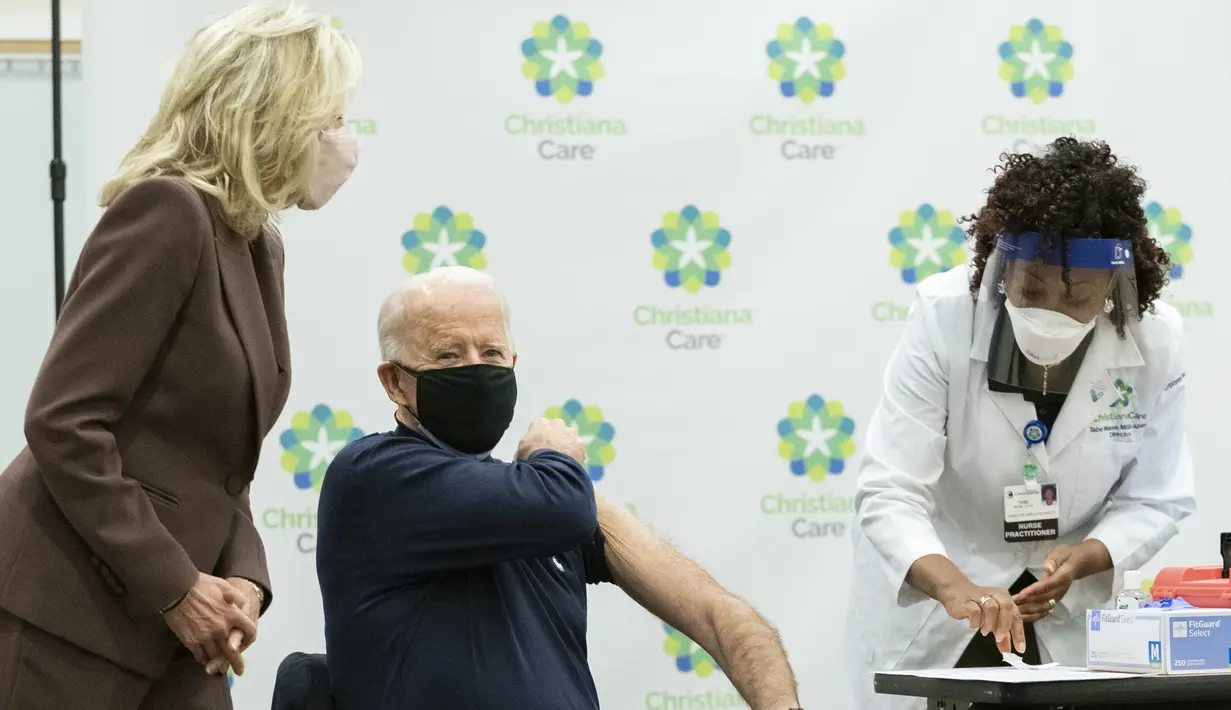 Presiden Amerika Serikat terpilih, Joe Biden, didampingi istrinya Jill Biden, menggulung lengan bajunya untuk menerima dosis pertama vaksin virus corona corona Pfizer-BioNTech di Rumah Sakit Christiana di Newark, Delaware, Senin (21/12/2020). (AP Photo/Carolyn Kaster)