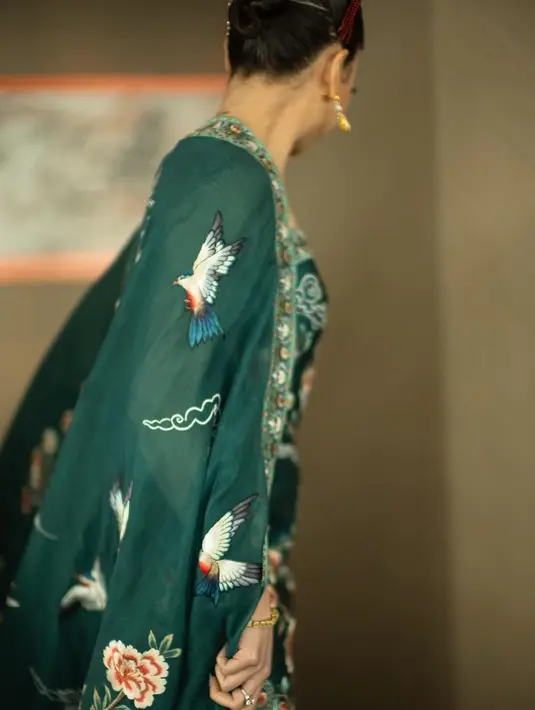 Ia nampak mengenakan cheongsam dress hijau turqoise rancangan Hian Tjen [@clarissatanoe]