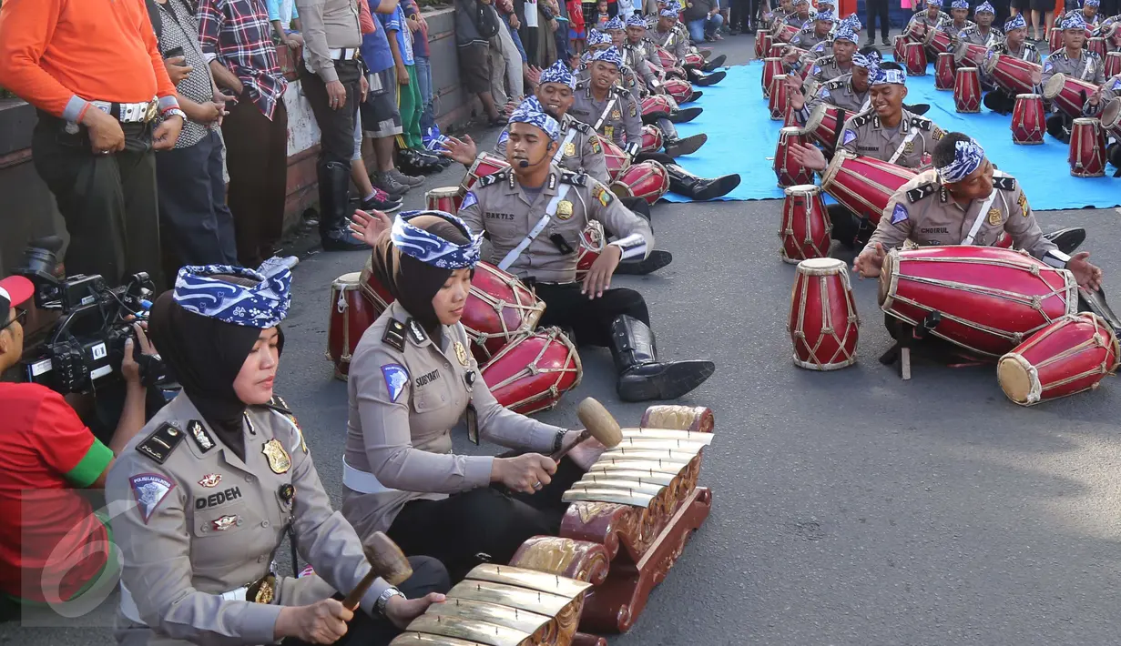Aksi polisi dan polwan memainkan alat musik gamelan dan gendang pada kegiatan car free day di Jakarta, Minggu (9/4). Dalam atraksi tersebut mereka melakukan sosialisasi “Polwanku Sahabatku”. (Liputan6.com/Angga Yuniar)