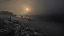 Anak-anak tunawisma mengumpulkan sampah untuk dijual kembali saat kebakaran besar melanda tempat pembuangan sampah Ghazipur di New Delhi, India (28/3/2022). (AP Photo/Manish Swarup)