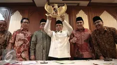 Ketua Umum PBNU KH Said Aqil Siradj mengangkat lambang negara Garuda Pancasila usai menggelar konferensi pers di Gedung PBNU, Jakarta, Senin (30/5). PBNU menyambut positif penetapan 1 Juni sebagai Hari Lahir Pancasila. (Liputan6.com/Faizal Fanani)