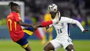 Gelandang Timnas Spanyol, Nico Williams (kiri) berusaha mengontrol bola di depan gelandang Timnas Inggris, Kobbie Mainoo pada laga final Euro 2024 di Olympiastadion, Berlin, Jerman, Minggu (14/7/2024). (AP Photo/Manu Fernandez)