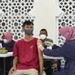 Seorang pria menerima dosis vaksin virus corona COVID-19 Sinovac saat pelaksanaan vaksinasi di Masjid Raya Baiturrahman, Banda Aceh, Aceh, Selasa (7/9/2021). (CHAIDEER MAHYUDDIN/AFP)