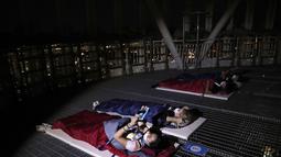 Orang-orang menginap di tempat berkemah semalam di atap gedung pencakar langit di Seoul, Korea Selatan (7/8/2020). Menara Lotte World membuka area berkemah jarak sosial di atap menara dan tanah untuk orang-orang yang jenuh di cuaca musim panas dan Covid-19. (AP Photo/Lee Jin-man)