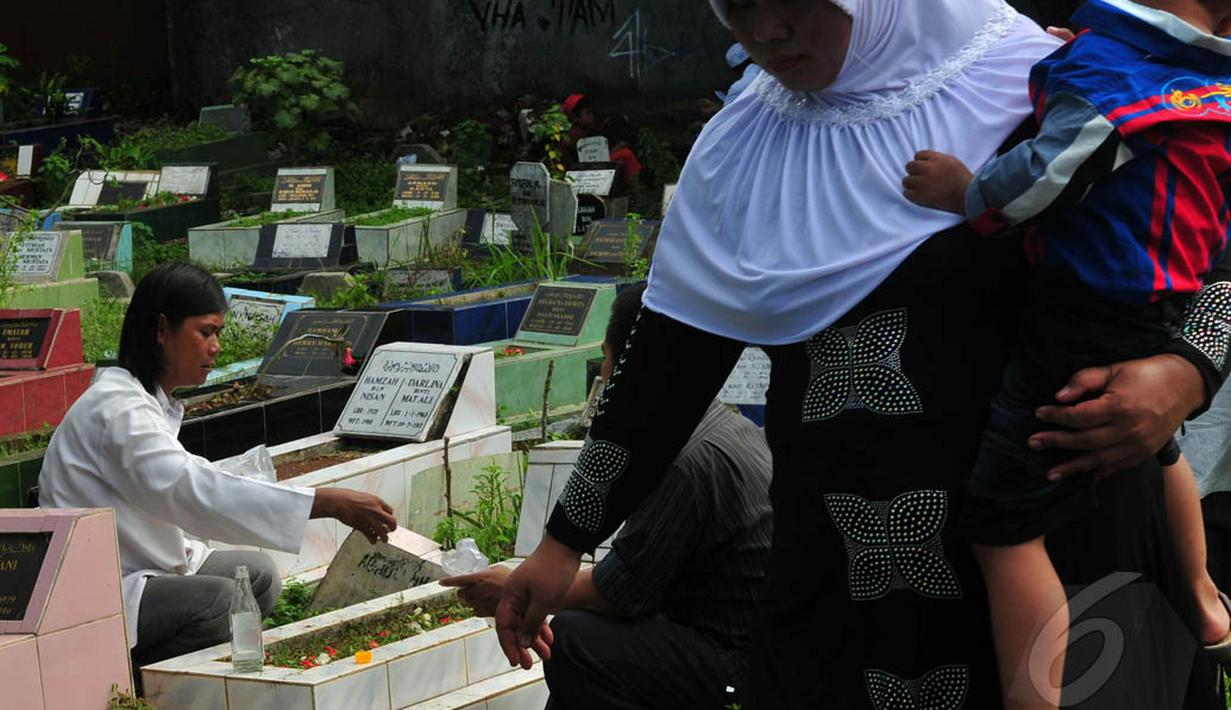 Para peziarah membawa aneka bunga lainnya untuk ditaburkan di atas makam TPU Karet Bivak, Jakarta, Senin (28/7/14). (Liputan6.com/Johan Tallo)