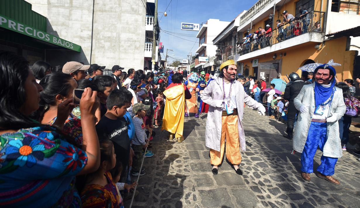 Anggota Saturno Club mengenakan kostum selama berpatispasi dalam parade Dance of Costumes tahunan di sepanjang jalan kota Sumpango, Guatemala, Senin (30/12/2019). Parade kostum yang menampilkan karakter televisi dan film ini untuk memeriahkan malam pergantian tahun. (ORLANDO ESTRADA/AFP)