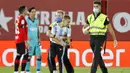 Petugas keamanan menangkap seorang fans yang nekat menerobos lapangan saat pertandingan antara Mallorca melawan Barcelona di Stadion Son Moix, Minggu (14/6/2020). Fans tersebut ingin berfoto dengan Lionel Messi. (AP/Francisco Ubilla)