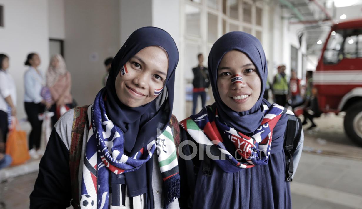 Dua Mahasiswi kembar asal Thailand Tanrada Makaew dan Teerada Makaew menyempatkan diri untuk menonton tim Gajah Putih pada laga Final Piala AFF 2016 di Stadion Pakansari, Bogor, (14/12/2016). (Bola.com/Nicklas Hanoatubun)
