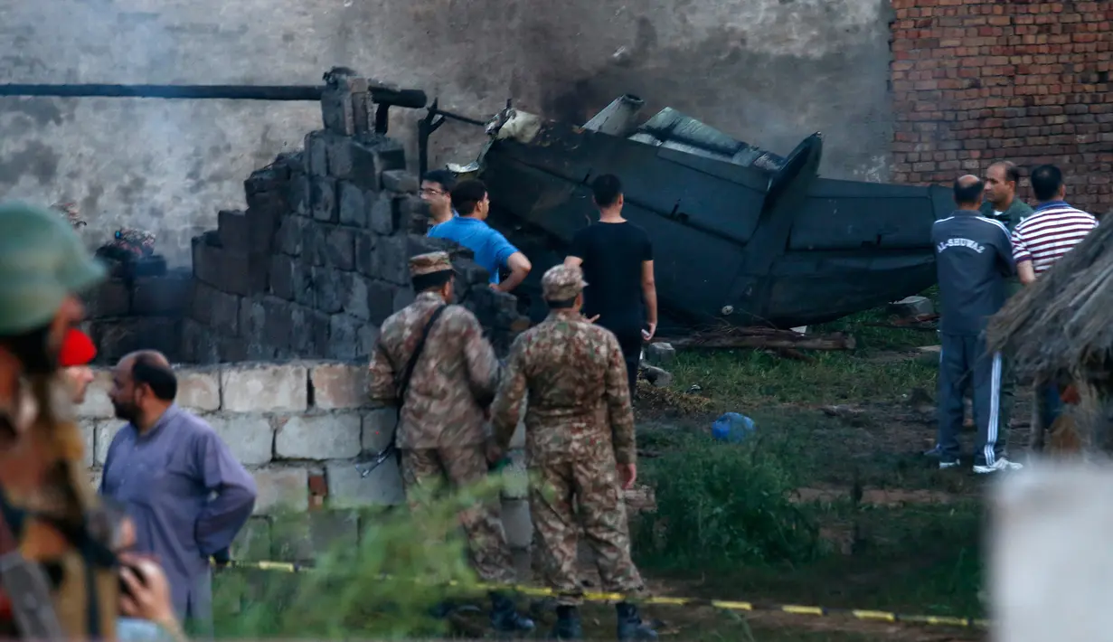Pejabat militer Pakistan memeriksa lokasi kecelakaan pesawat di Rawalpindi, Pakistan, Selasa (30/7/2019). Korban tewas termasuk dua pilot dan tiga kru pesawat. (AP Photo/Anjum Naveed)
