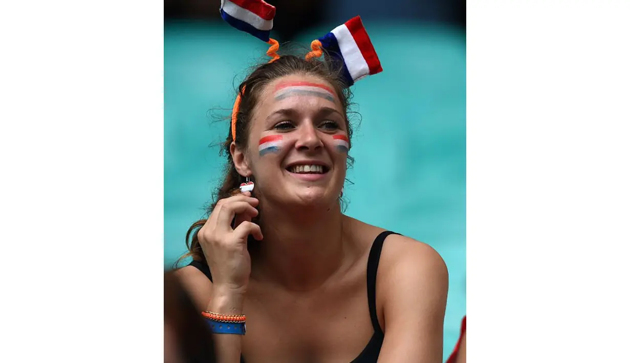 Wajah salah satu pendukung Belanda dipenuhi hiasan bendera kebangsaan tim berjuluk De Oranje, (14/6/2014). (AFP PHOTO/Javier Soriano)