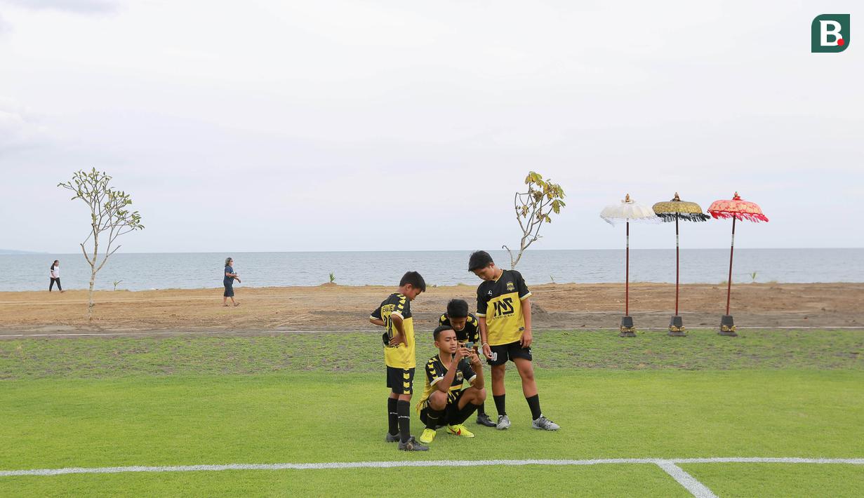Sejumlah pesepak bola cilik saat berada di Training Ground Bali United, Gianyar, Senin (28.03/2022). Mereka tampak senang menjajal lapangan latihan Bali United yang berada di pinggir pantai. (Bola.com/ M Iqbal Ichsan)