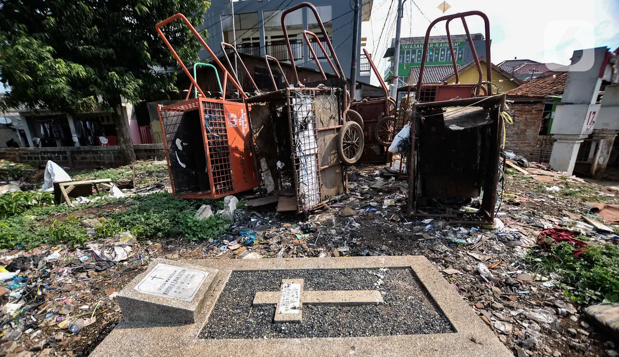 Sebuah makam berada dekat dengan gerobak sampah di TPU Menteng Pulo 2, Jakarta, Senin (9/12/2019). Minimnya kesadaran warga setempat ditambah tidak adanya fasilitas TPA dan perawatan pengelola TPU menyebabkan kondisi kompleks makam memprihatinkan akibat dipenuhi sampah.(merdeka.com/Iqbal S. Nugroho)