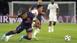Pemain Paris Saint-Germain, Kylian Mbappe (kiri) mengeram kesakitan saat berebut bola dengan pemain Nice, Sofiane Diop pada laga lanjutan Ligue 1 2023/2024 di Parc des Princes, Paris, Prancis, Sabtu (16/09/2023). (AP Photo/Michel Euler)