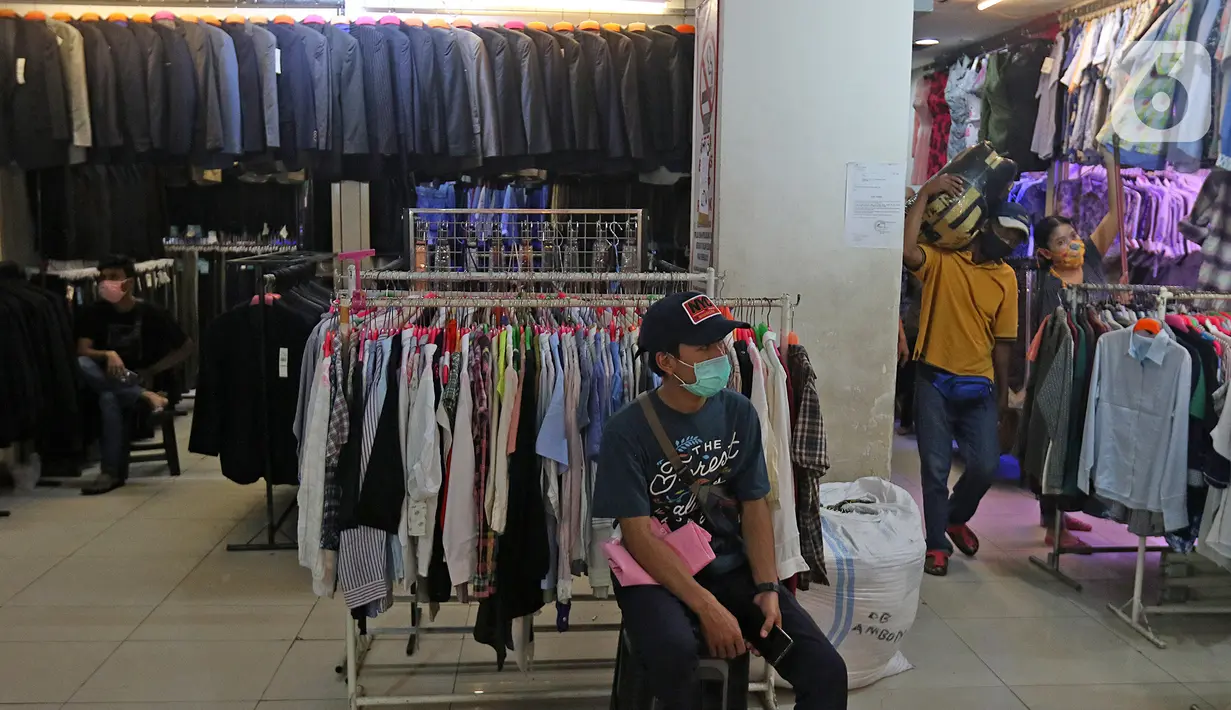Seorang pria duduk di depan kios pakaian bekas Pasar Senen Blok III, Jakarta, Kamis (11/6/2020). Pasar yang tetap buka saat PSBB dengan pembatasan jam operasional ini akan kembali dibuka secara normal pada 15 Juni 2020 dengan aturan protokol kesehatan COVID-19. (Liputan6.com/Herman Zakharia)