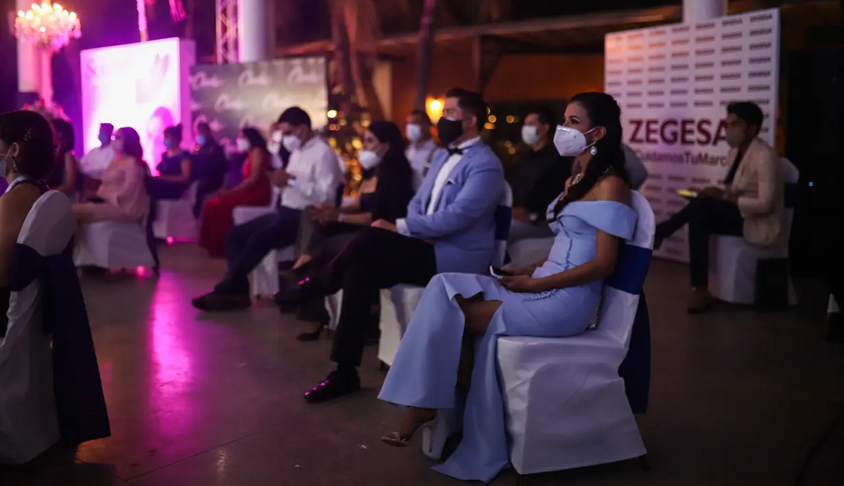 Penonton yang mengenakan masker menyaksikan kontes Miss Nikaragua 2020 di tengah pandemi Covid-9 di Managua, 8 Agustus 2020. Acara tersebut berlangsung dengan tetap menerapkan protokol jarak sosial itu dihadiri 85 orang dari kru produksi. (AP Photo/Alfredo Zuniga)