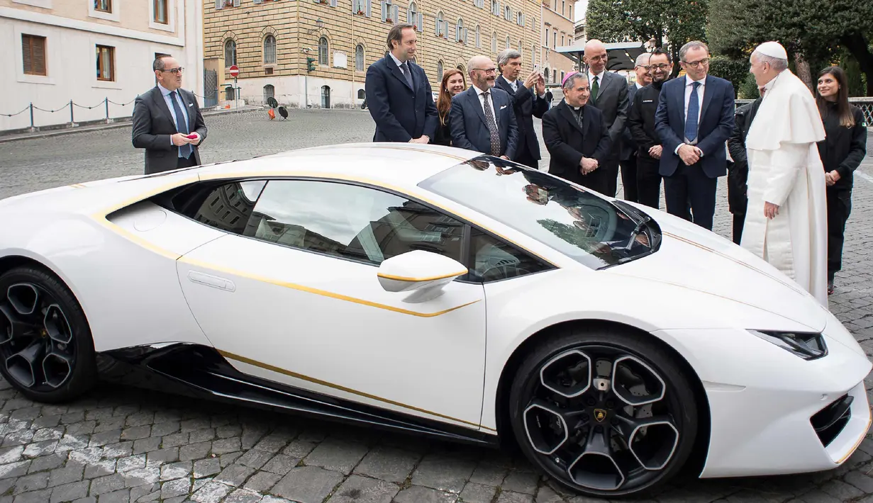 Paus Fransiskus saat menerima hadiah mobil Lamborghini Huracan di Vatikan, Rabu (15/11). Perusahaan Lamborghini memberi hadiah mobil Lamborghini Huracan berwarna putih untuk Paus Fransiskus. (L'Osservatore Romano/Pool Photo via AP)
