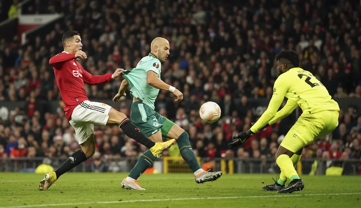 Penyerang Manchester United atau MU, Cristiano Ronaldo mencoba untuk mencetak gol di belakang bek Omonia Nicosia, Nemanja Miletic  pada laga matchday 4 fase grup Liga Europa 2022/2023 di Old Trafford, Jumat dini hari WIB (14/10/2022). Christian Eriksen, Jadon Sancho melakukan kerja sama apik yang dituntaskan McTominay untuk memastikan kemenangan MU. (AP Photo/Dave Thompson)
