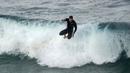 Seorang peselancar melompat dari papannya saat berselancar di Pantai Bronte, Sydney, Australia, 24 Mei 2022. (AP Photo/Mark Baker)