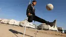 Pengungsi anak Irak Jasim Abudllah Jasim, 13, yang menurut keluarganya kehilangan kakinya dalam serangan udara di Baiji, memainkan sepak bola di Debaga kamp, di pinggiran Erbil, Irak November (24/11). (REUTERS/Mohammed Salem) 