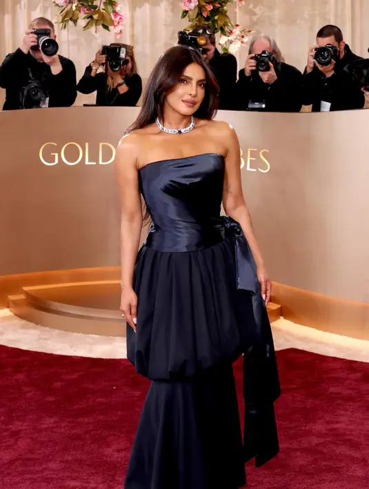 Salah satu yang paling menyita sorotan adalah Priyanka Chopra-Jonas. Ia tampil anggun dalam bustier satin navy berpotongan drapery yang dipadukan dengan rok sutra navy mengalir. Look ini menonjolkan kekuatan struktur khas couture Dior dengan sentuhan sensual yang refined. [Dok/DIOR].