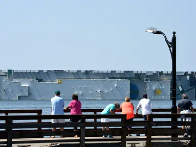 Warga melihat kapal kargo Golden Ray yang terbalik di lepas pantai negara bagian Georgia, Amerika Serikat, Minggu (8/9/2019). Kapal kargo Korea Selatan yang mengangkut 4.000 mobil itu terbalik saat menuju Timur Tengah. (Bobby Haven/The Brunswick News via AP)