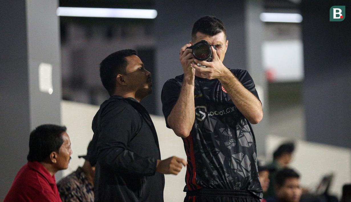 Pemain Persija Jakarta, Ondrej Kudela (kanan) didampingi fotografer Persija Jakarta, Khairul Imam sedang memotret saat sesi latihan menjelang laga terakhir BRI Liga 1 2022/2023 di lapangan latih Jakarta International Stadium (JIS), Kamis (13/04/2023). Macan Kemayoran akan menjamu PSS Sleman di Stadion Utama Gelora Bung Karno (SUGBK) pada Sabtu (15/04/2023). (Bola.com/Bagaskara Lazuardi)