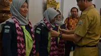 Kepala Dinas Pemuda dan Olahraga (Kadispora) Palembang Ahmad Zazuli mengalungkan kain jumputan ke tiga atlit Mafesripala (Liputan6.com / Nefri Inge)