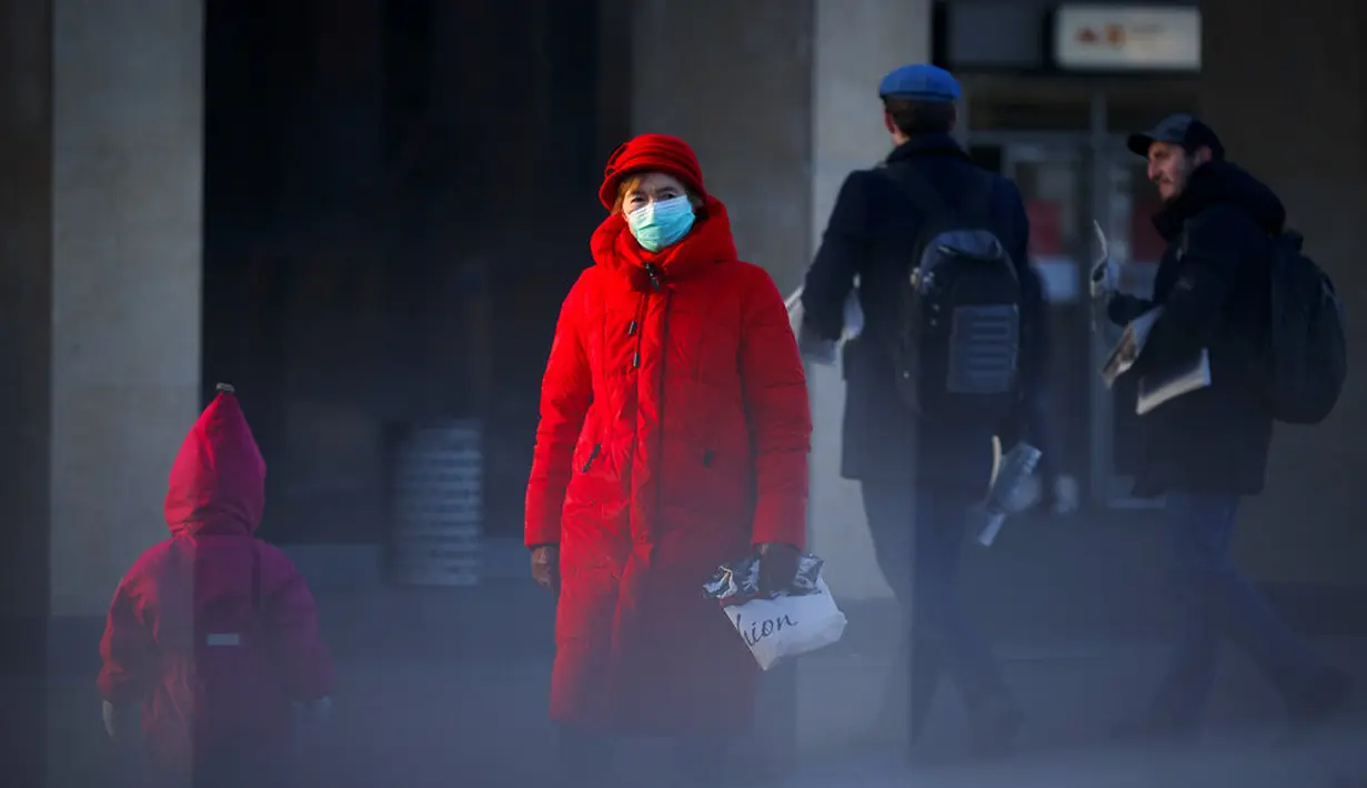 Seorang wanita yang mengenakan masker untuk membantu mengekang penyebaran virus corona COVID-19 berjalan di Moskow, Rusia, Rabu (2/12/2020). Rusia memerintahkan penggunaan masker di seluruh negeri dan sebagian besar pembatasan ringan yang bervariasi. (AP Photo/Alexander Zemlianichenko)
