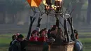 Para kru bekerja membantu para wisatawan saat balon udara panas mendarat di kota Luxor, Kairo, Mesir (13/12). Balon udara panas tersebut juga bagian dari pariwisata kota Luxor. (Reuters/Amr Abdallah Dalsh)
