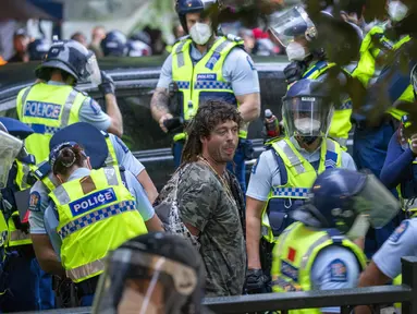 Seorang demonstran ditangkap pada protes menentang mandat vaksin virus corona di Wellington, Selandia Baru, Rabu (2/3/2022). Sejak awal pandemi, Selandia Baru telah melaporkan kurang dari 100 kematian akibat virus di antara populasinya yang berjumlah 5 juta. (Mark Mitchell/New Zealand Herald via AP)